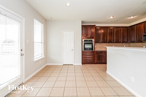 A kitchen with brown cabinets and a white counter.