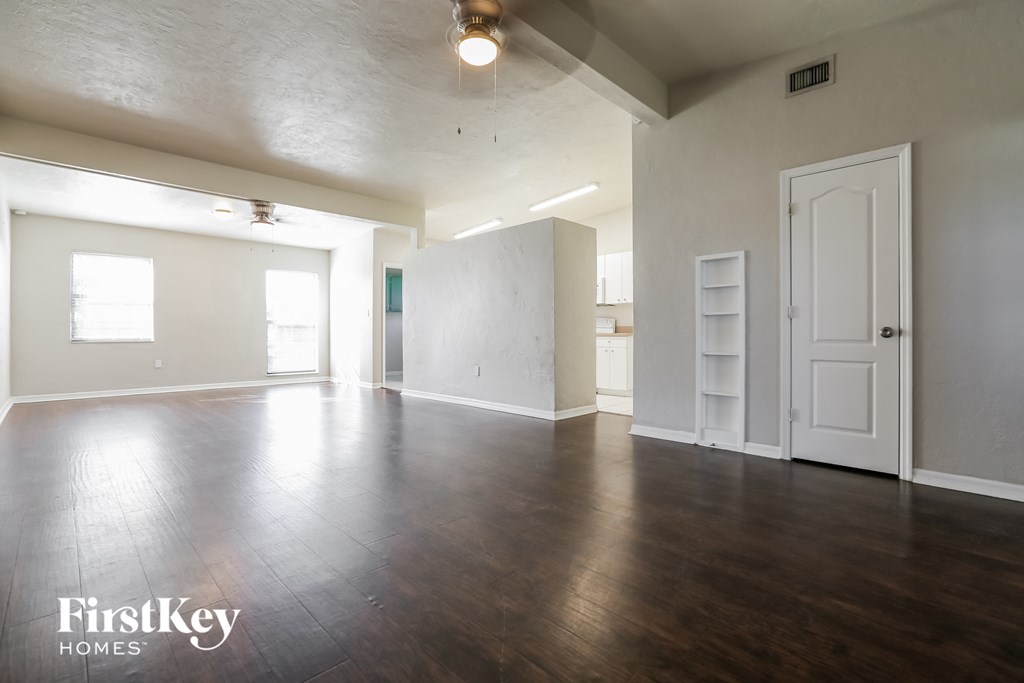 an empty living room with white walls and wood floors