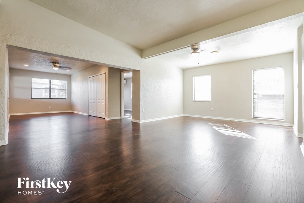 an empty living room with wood flooring and white walls