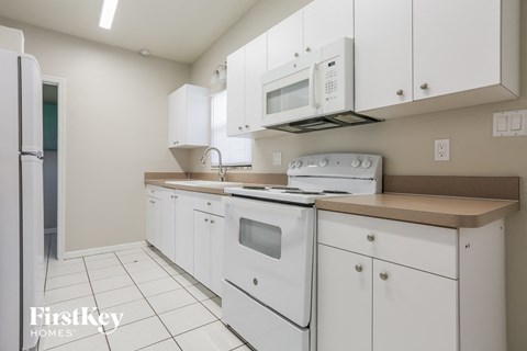 a white kitchen with white appliances and white cabinets