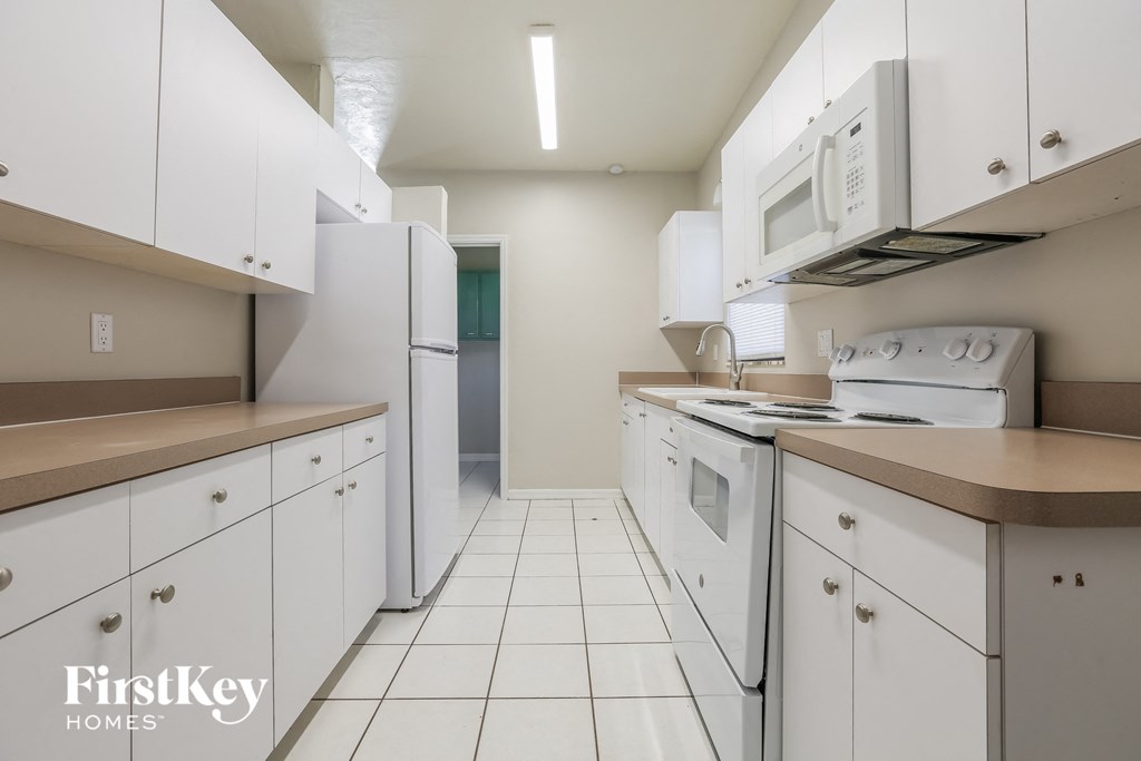 a kitchen with white appliances and counters and white cabinets