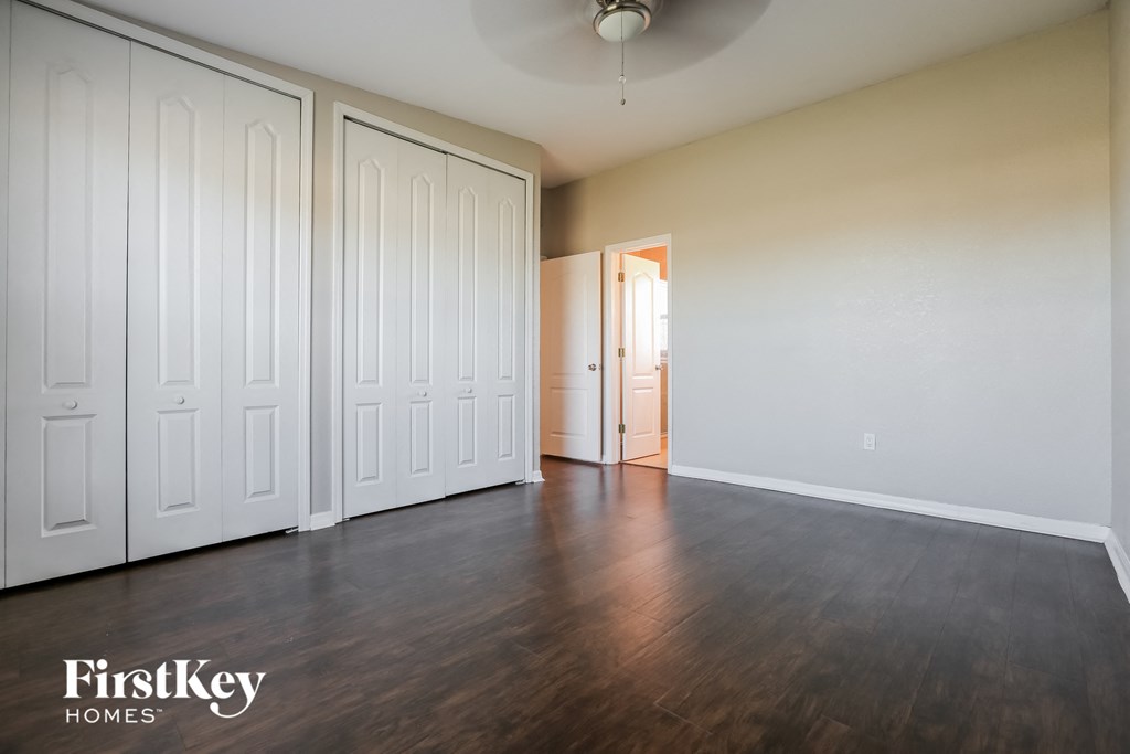 an empty living room with wood floors and white closets