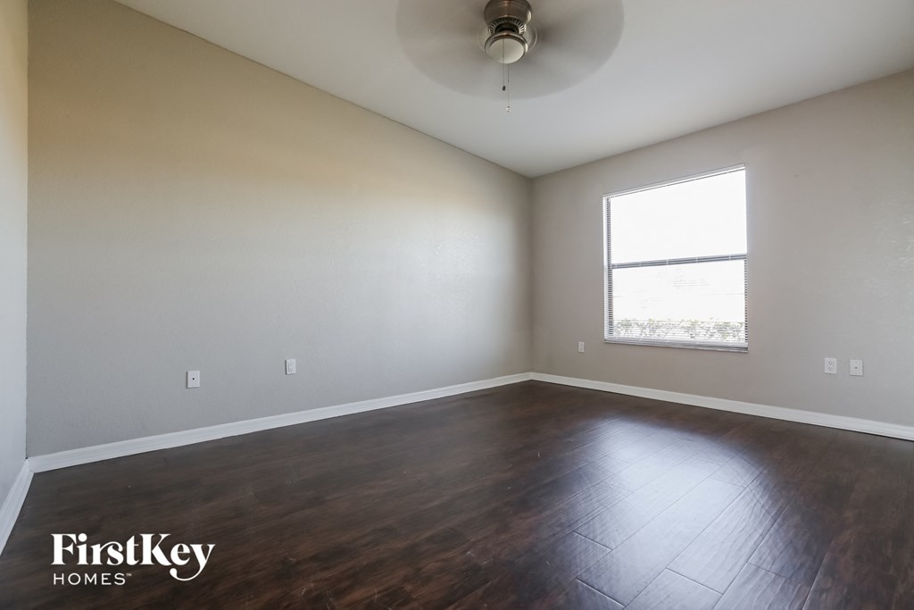 an empty room with wood floors and a window