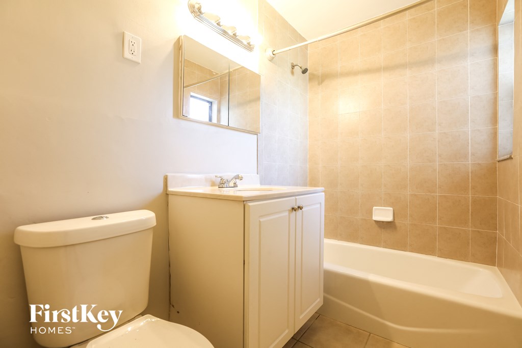 a bathroom with a toilet and a sink and a bath tub