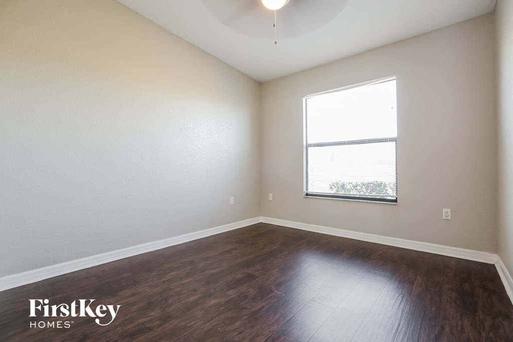 the living room with hardwood flooring and a window