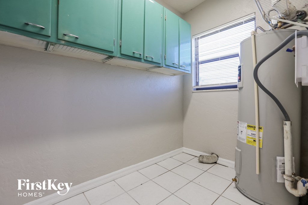 a kitchen with a refrigerator and green cabinets