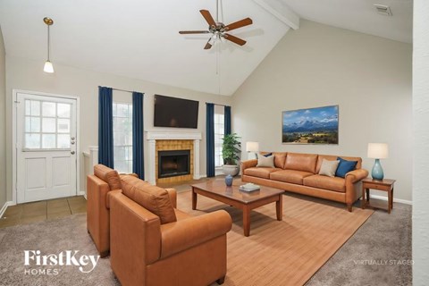 A living room with a fireplace and a painting on the wall.