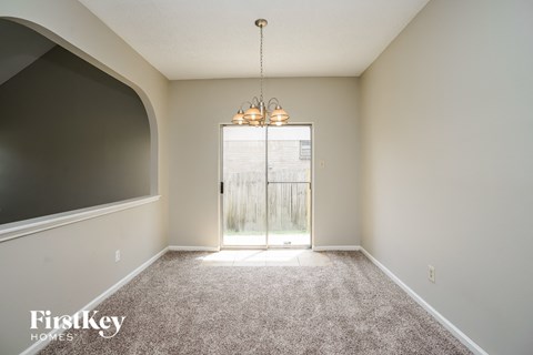 a spacious living room with carpet and a door to a patio