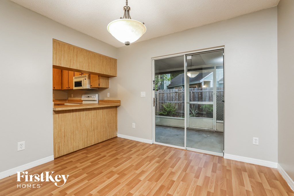 an empty living room and kitchen with a sliding glass door to a patio