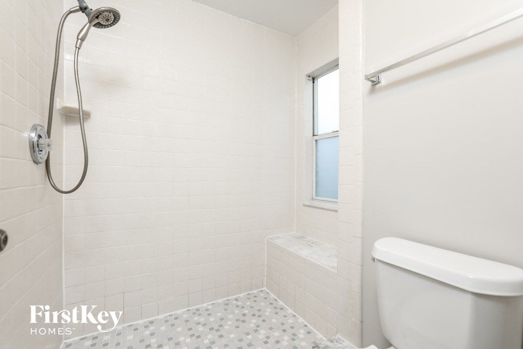 a white bathroom with a shower and a toilet
