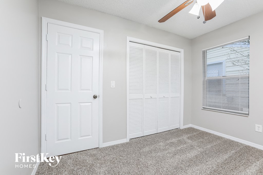 a bedroom with a closet and a door and a window