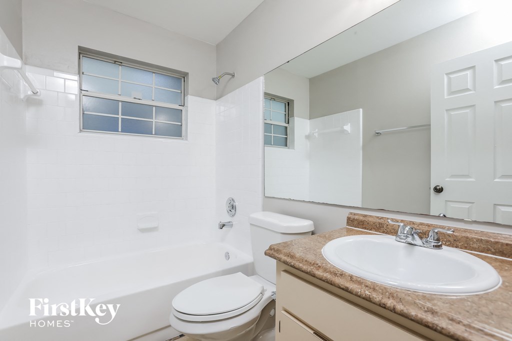 a bathroom with a sink toilet and tub and a mirror