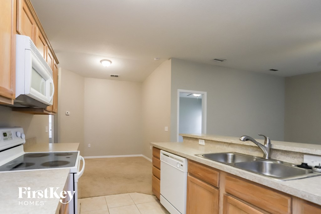 a kitchen with white appliances and wooden cabinets and a sink