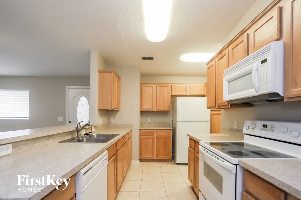 a kitchen with white appliances and wooden cabinets