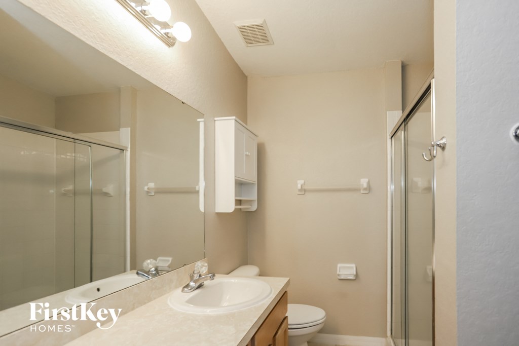 a bathroom with a sink and a shower and a toilet