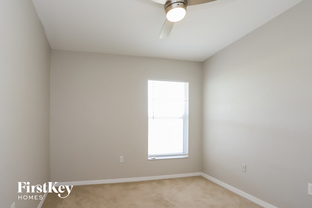 a bedroom with a ceiling fan and a window