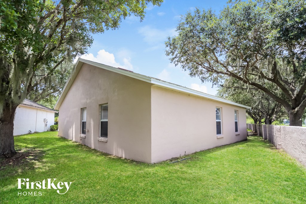 a small white house with trees and a lawn