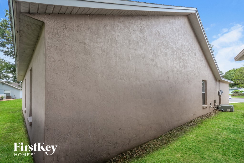 the side of a house with a grassy yard and a garage