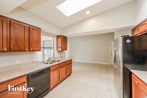 a kitchen with wooden cabinets and a sink and a refrigerator