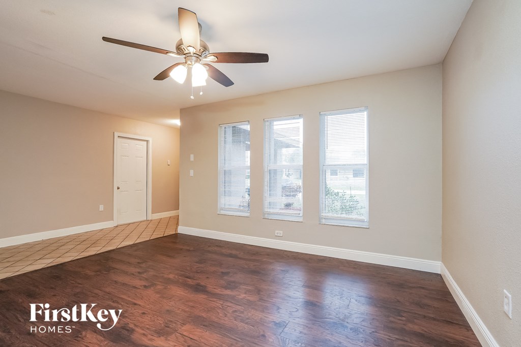 a living room with wood floors and a ceiling fan