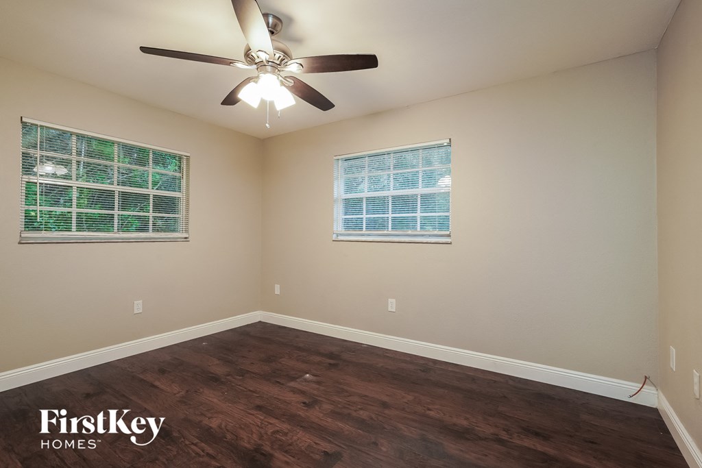 a bedroom with hardwood flooring and a ceiling fan