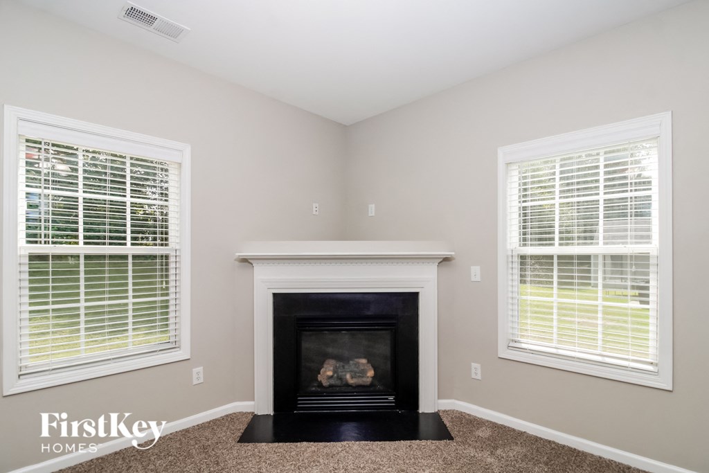 a living room with a fireplace and two windows