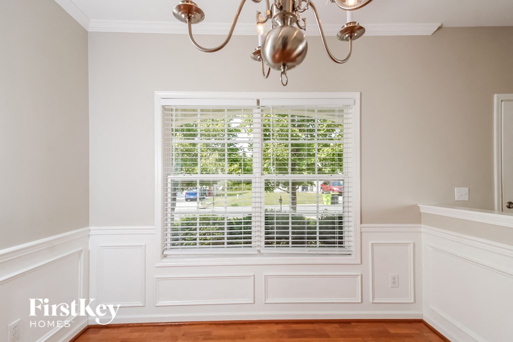 a dining room with a window and a chandelier