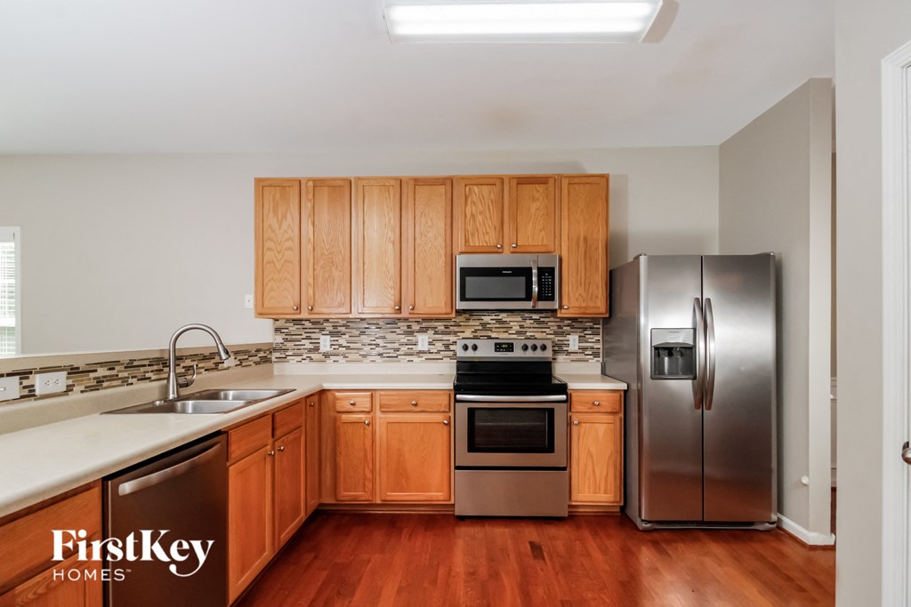 a kitchen with wooden cabinets and stainless steel appliances