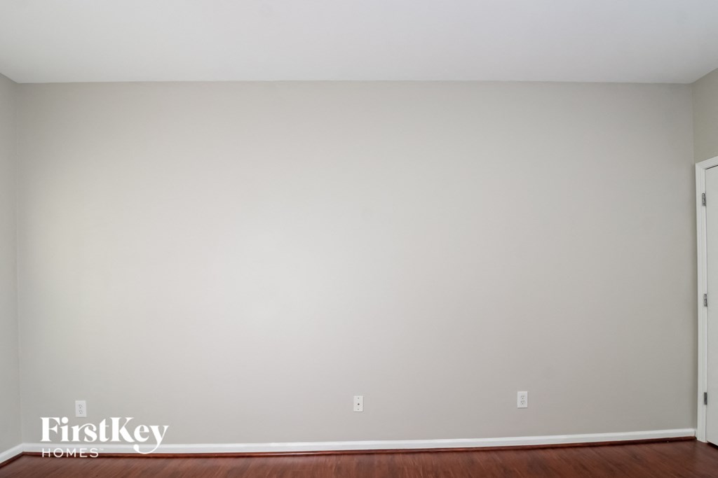 a blank wall in a room with wooden floors and a door