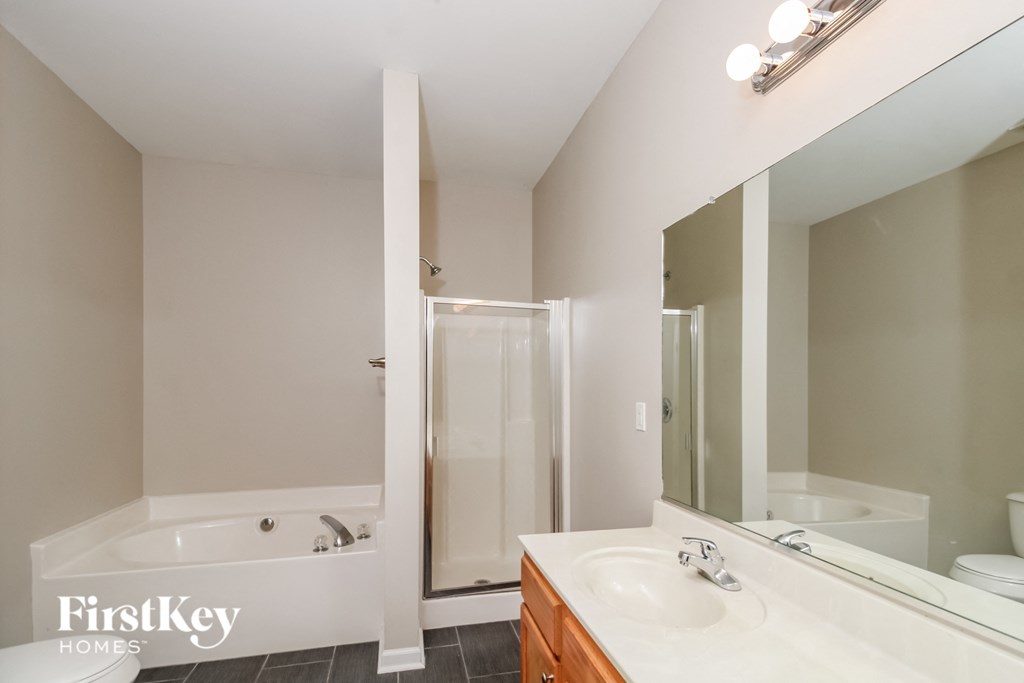 a bathroom with a large mirror and a tub and a sink