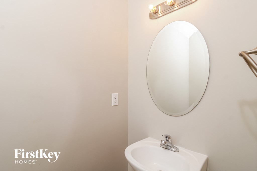 a white bathroom with a white sink and a mirror