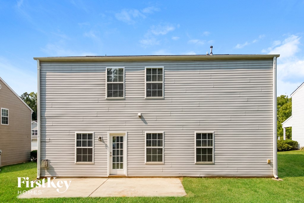 the front of a small white building with windows and a garage
