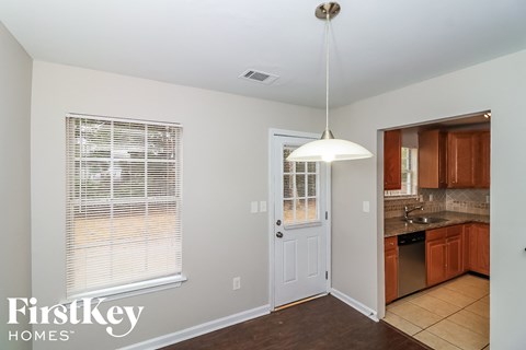 a kitchen with a white door and a sink and a window
