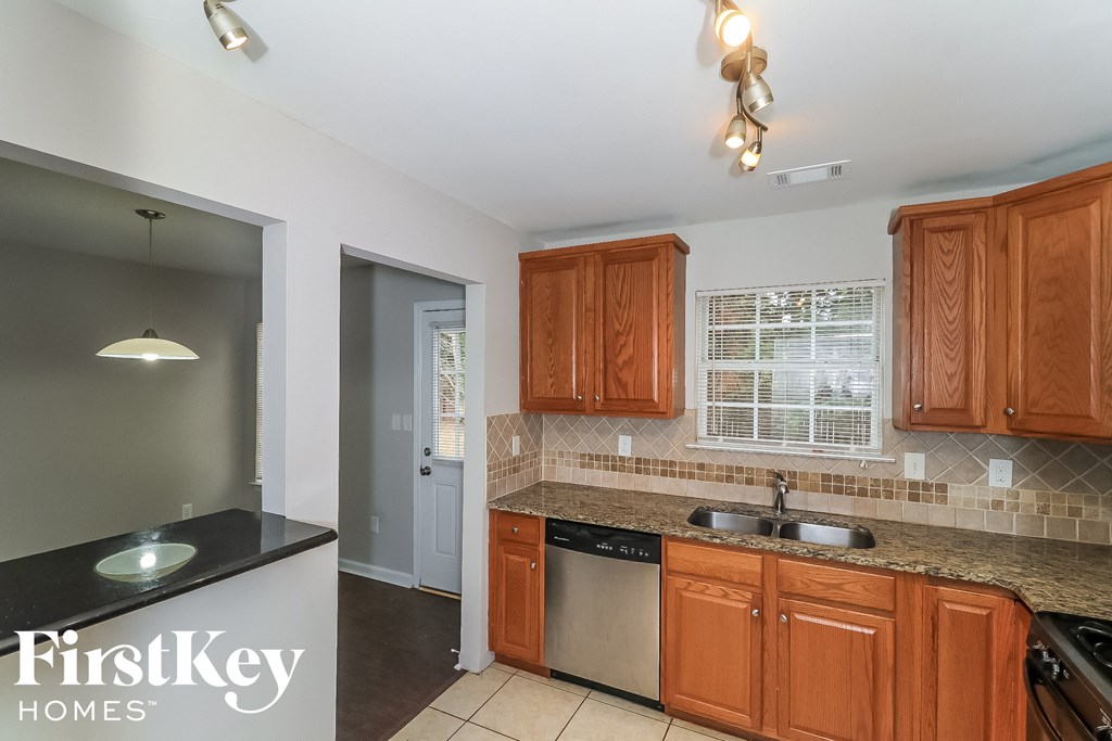 a kitchen with wooden cabinets and granite counter tops and a sink