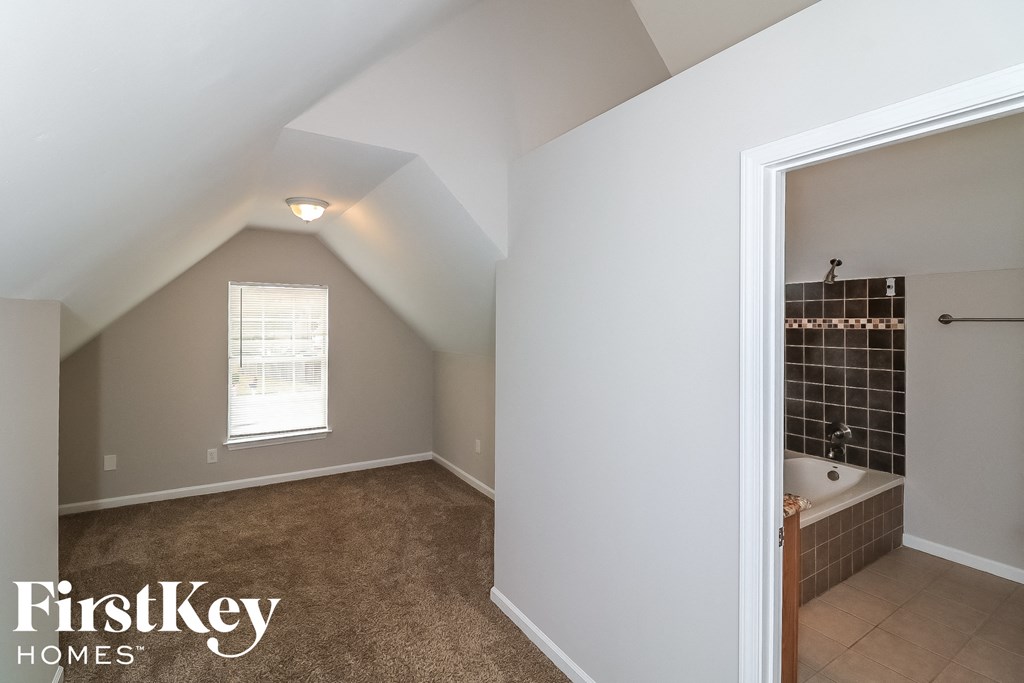 a small bathroom with a tub and a shower and a window