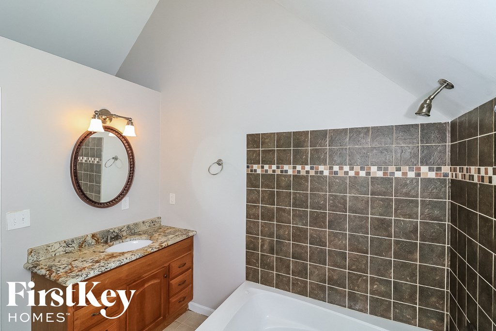 a bathroom with a tub and a sink and a mirror
