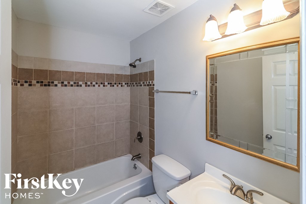 a bathroom with a white toilet and a tub and a sink