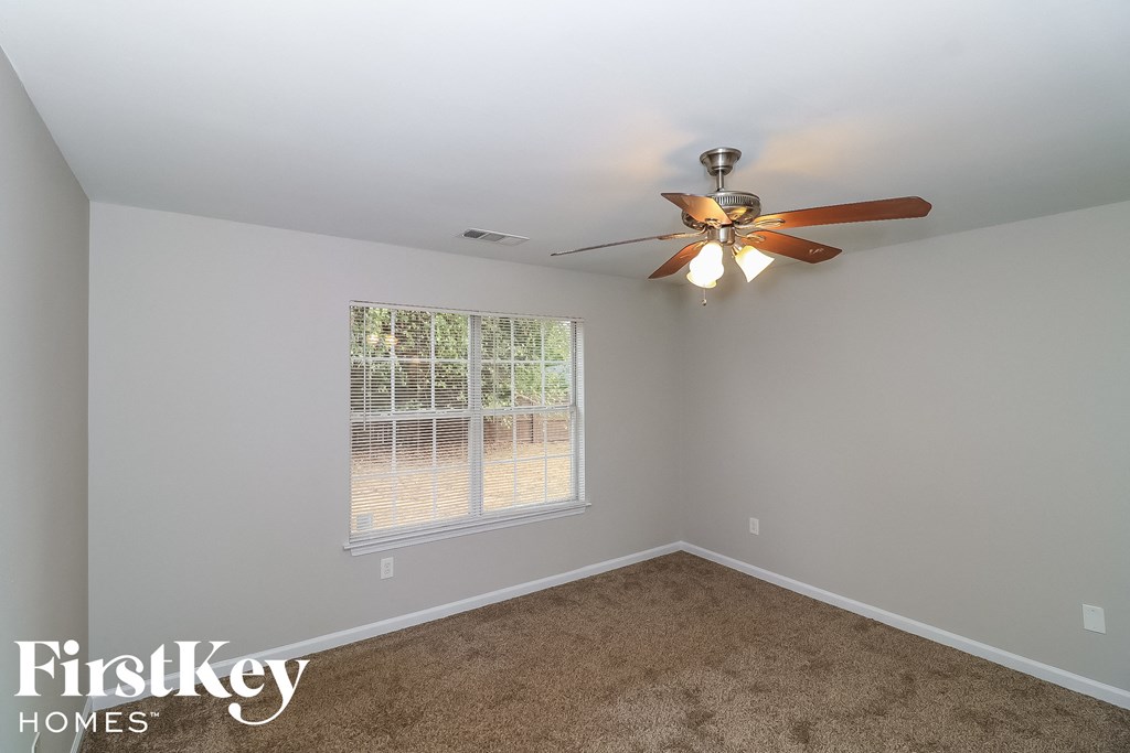 a bedroom with a ceiling fan and a window