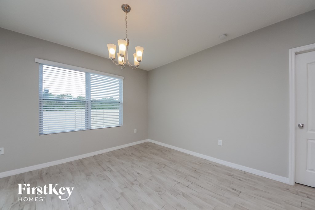 the spacious living room with wood floors and a large window