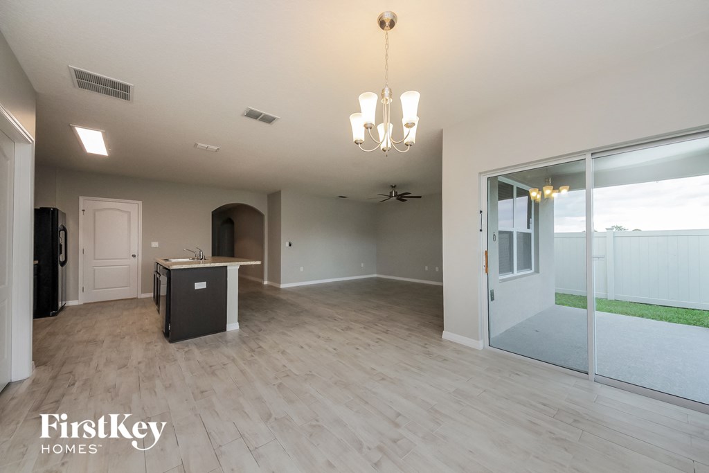 an empty living room and dining room with sliding glass doors