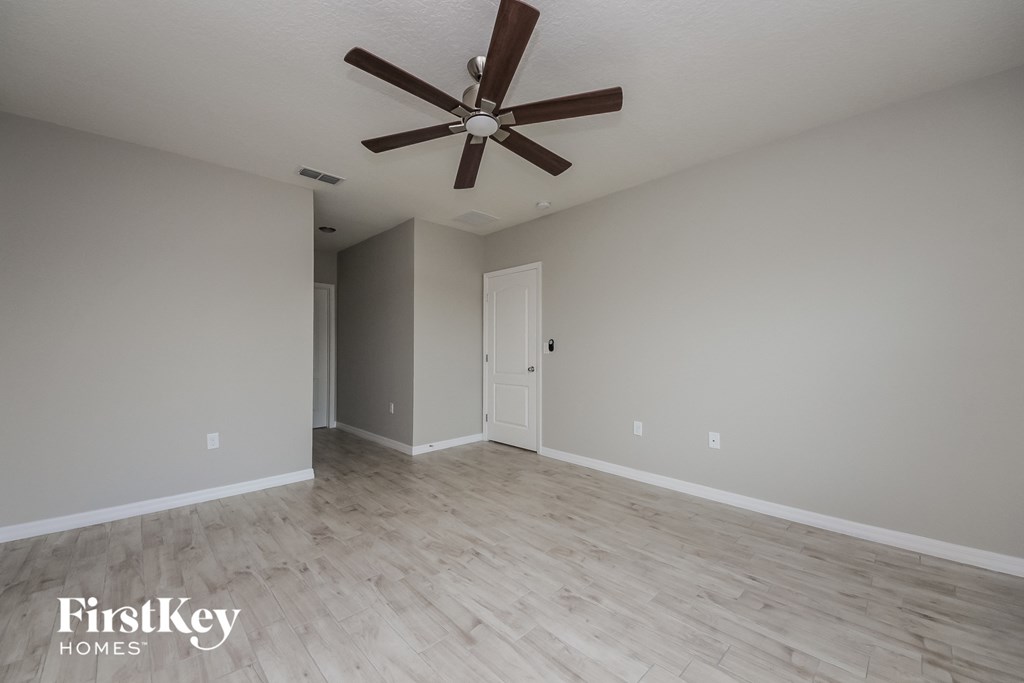an empty living room with a ceiling fan