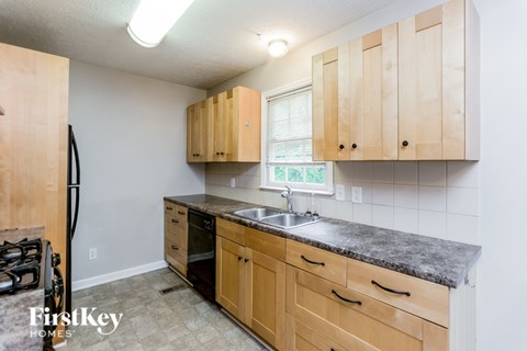 A kitchen with wooden cabinets and a granite countertop.
