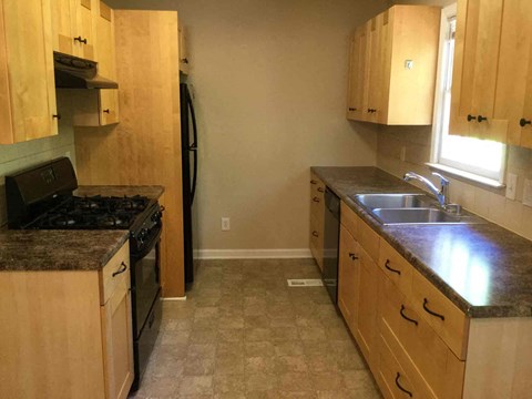 A kitchen with wooden cabinets and a granite countertop.