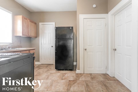 a kitchen with a black refrigerator and white doors