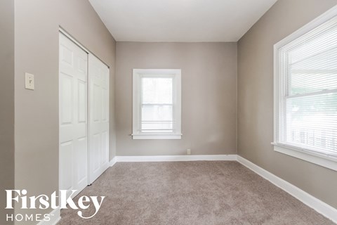 a bedroom with a carpeted floor and two windows