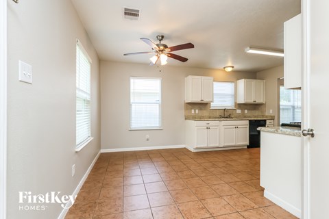 A kitchen area with a fan and cabinets.