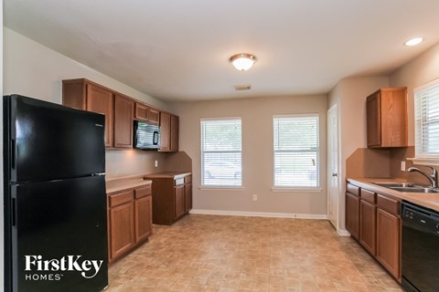a kitchen with wooden cabinets and a black refrigerator