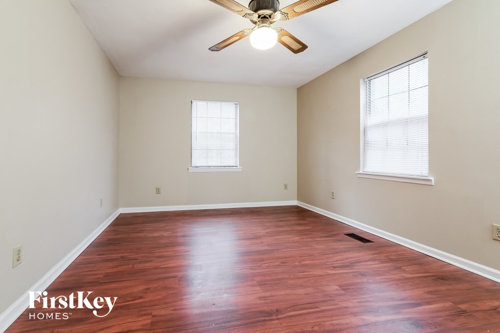 A room with a wooden floor and a ceiling fan.