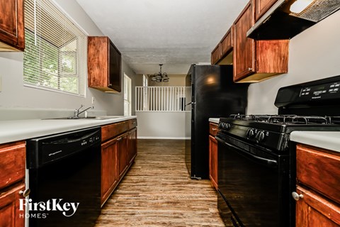 A kitchen with wooden cabinets and black appliances.