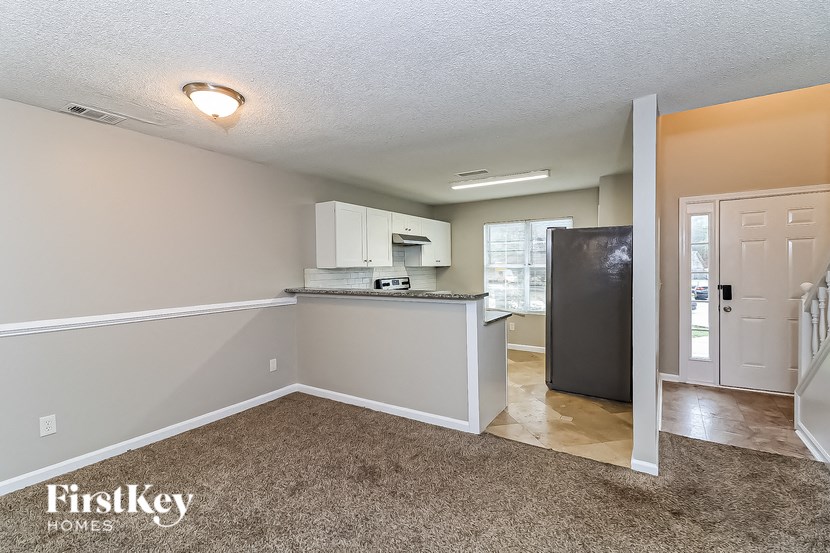 A kitchen area with a refrigerator, microwave, and cabinets.